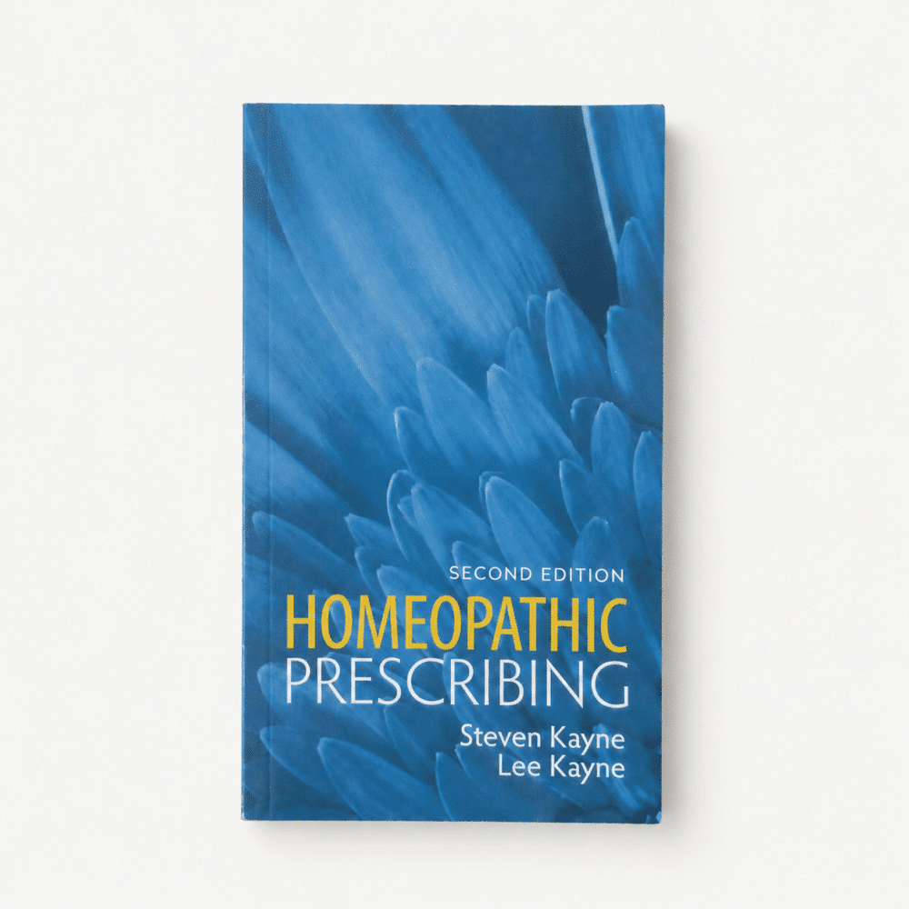blue book cover featuring a background with blue flower petals. Cover reads second edition homeopathic prescribing by Steven Kayne and Lee Kayne